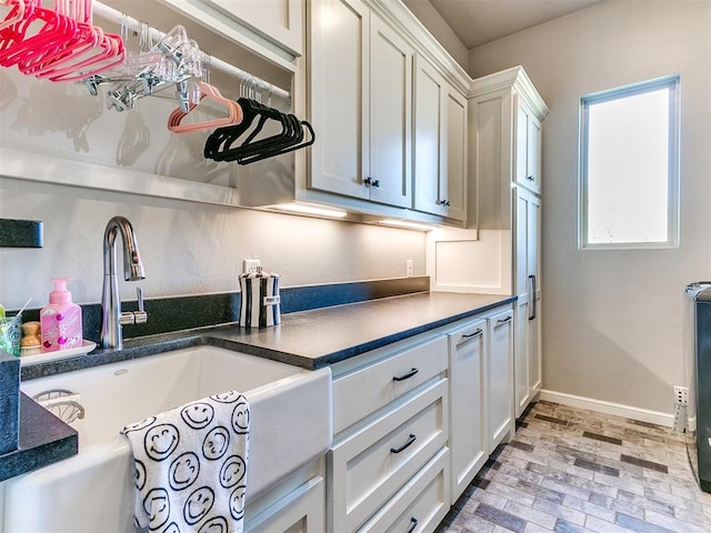 kitchen featuring white cabinetry and sink