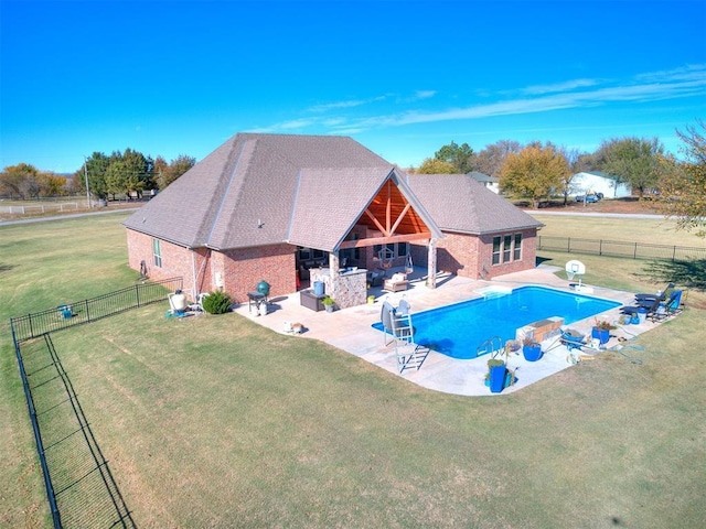 view of pool featuring a yard, a patio area, and a fireplace