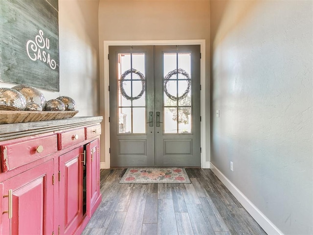 doorway with baseboards, dark wood finished floors, and french doors