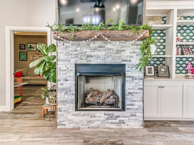 interior details with a stone fireplace and wood finished floors