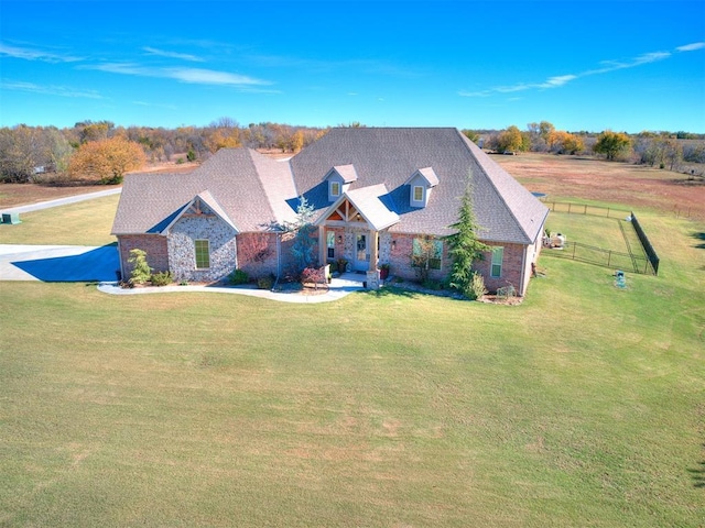 view of front of house featuring brick siding, fence, and a front yard