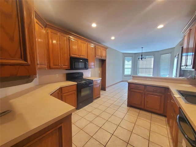 kitchen featuring kitchen peninsula, an inviting chandelier, hanging light fixtures, and black appliances