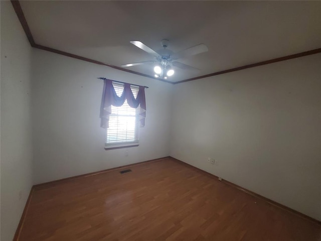 empty room with hardwood / wood-style flooring, ceiling fan, and crown molding