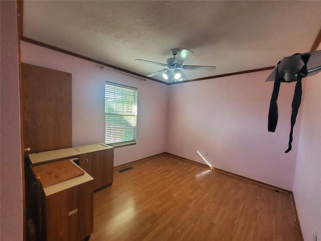 unfurnished room featuring light wood-type flooring, ceiling fan, and crown molding