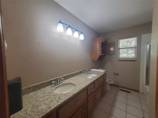 full bathroom featuring tile patterned floors, vanity, toilet, and bath / shower combo with glass door