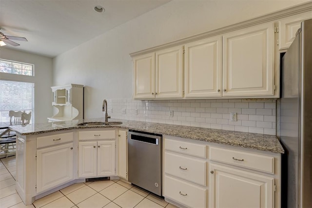 kitchen featuring light stone countertops, appliances with stainless steel finishes, kitchen peninsula, ceiling fan, and sink