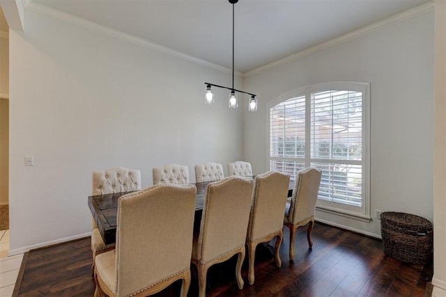 dining area featuring dark wood-type flooring, a healthy amount of sunlight, and ornamental molding