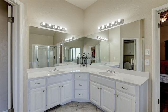 bathroom featuring tile patterned floors, vanity, and a shower with shower door