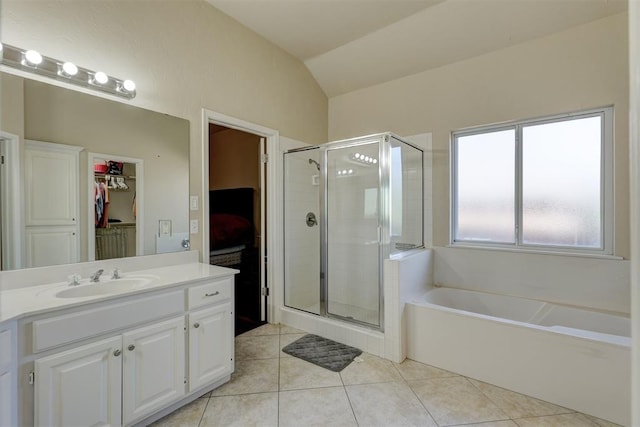 bathroom with tile patterned floors, vanity, independent shower and bath, and vaulted ceiling