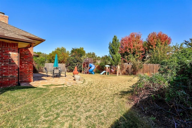 view of yard featuring a playground and a patio