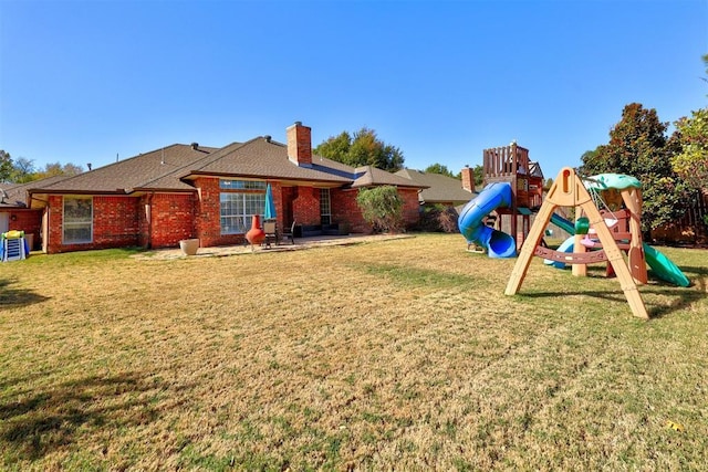 rear view of property with a playground and a yard