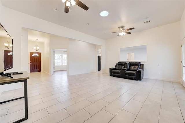 tiled living room featuring ceiling fan with notable chandelier