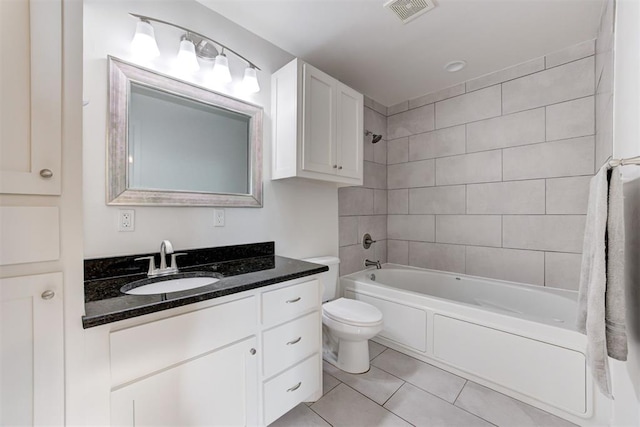 full bathroom featuring tile patterned flooring, tiled shower / bath combo, toilet, and vanity