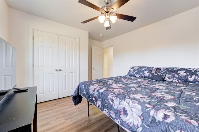 bedroom with a closet, light hardwood / wood-style floors, and ceiling fan