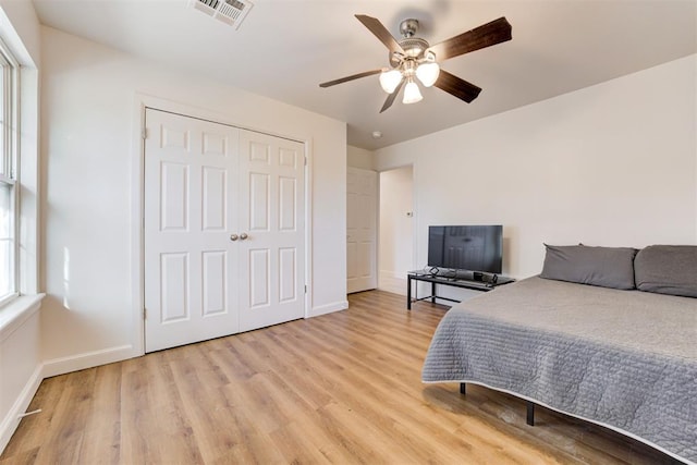 bedroom featuring ceiling fan, a closet, and light hardwood / wood-style floors