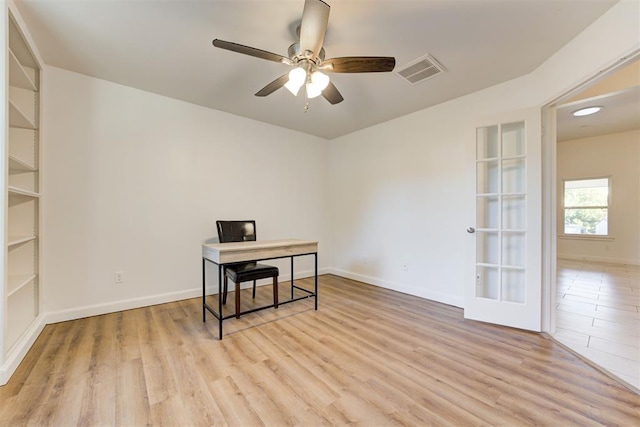 home office with ceiling fan, light hardwood / wood-style floors, and french doors