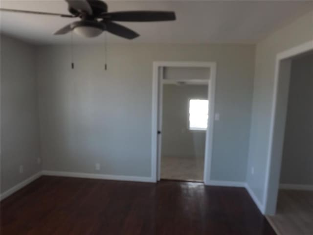 empty room featuring ceiling fan and dark hardwood / wood-style flooring