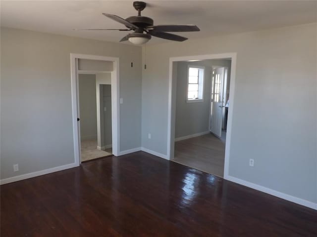 empty room with ceiling fan and dark hardwood / wood-style flooring