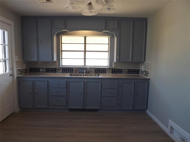 kitchen featuring gray cabinetry, decorative backsplash, sink, and dark hardwood / wood-style flooring