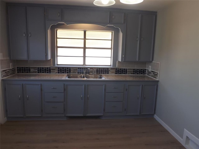 kitchen with decorative backsplash, gray cabinets, and sink