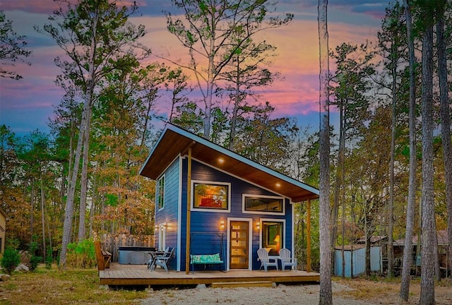 outdoor structure at dusk featuring a hot tub