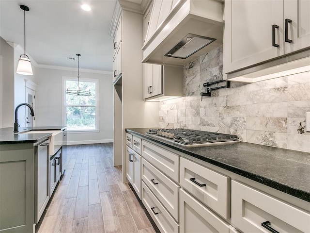 kitchen featuring white cabinets, decorative light fixtures, premium range hood, and light hardwood / wood-style floors