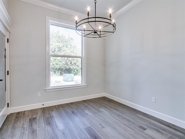 unfurnished dining area with a chandelier, wood-type flooring, and crown molding