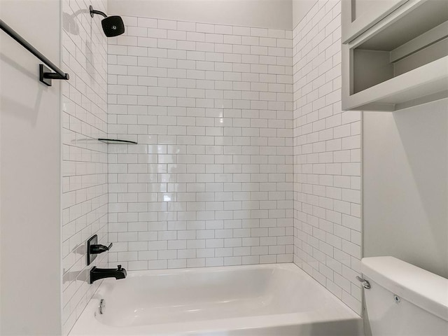 bathroom featuring tiled shower / bath combo and toilet