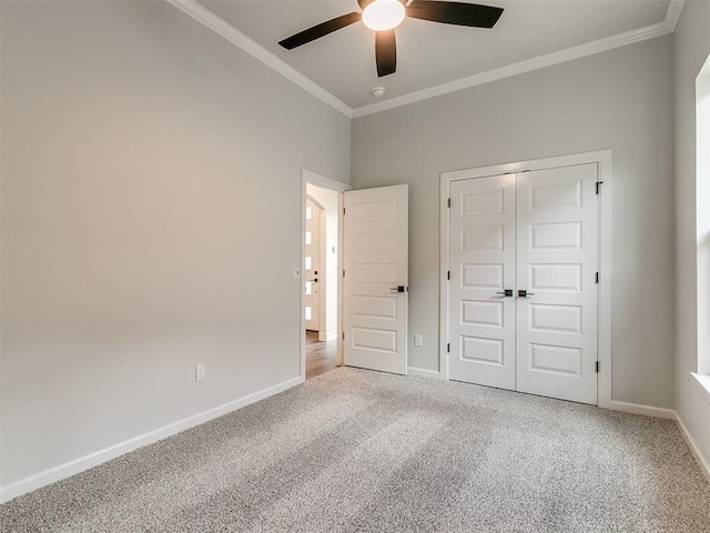 unfurnished bedroom with carpet, ceiling fan, ornamental molding, and a closet