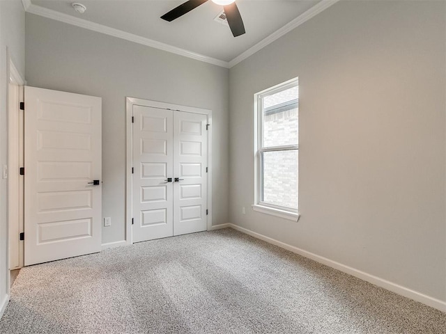 unfurnished bedroom with carpet floors, a closet, ceiling fan, and ornamental molding