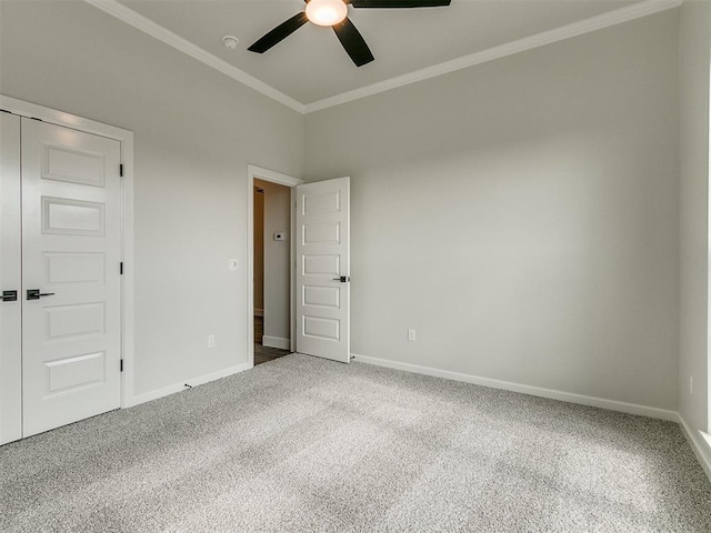 spare room with ceiling fan, crown molding, and carpet floors