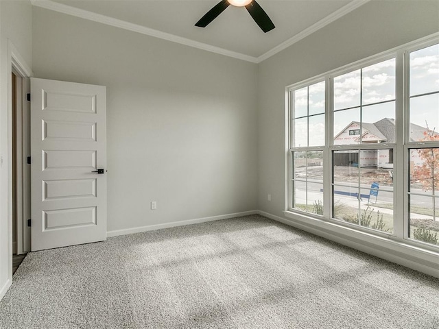 carpeted spare room featuring ceiling fan and ornamental molding