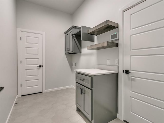 washroom with light tile patterned flooring and cabinets