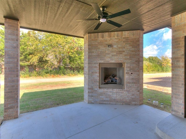 view of patio / terrace featuring an outdoor brick fireplace and ceiling fan