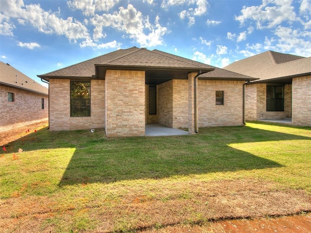 back of house featuring a lawn and a patio