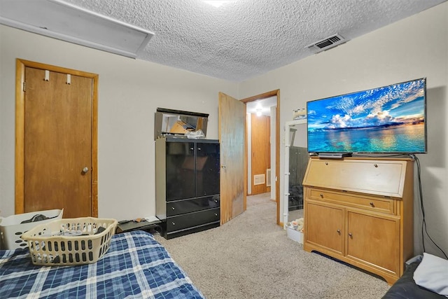 bedroom with a closet, light colored carpet, and a textured ceiling