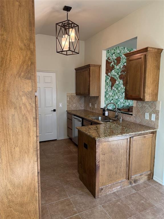 kitchen with decorative backsplash, stainless steel dishwasher, sink, decorative light fixtures, and tile patterned flooring