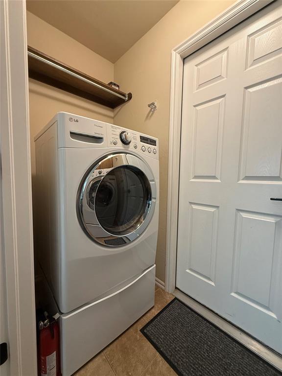 laundry room with washer / dryer and light tile patterned floors