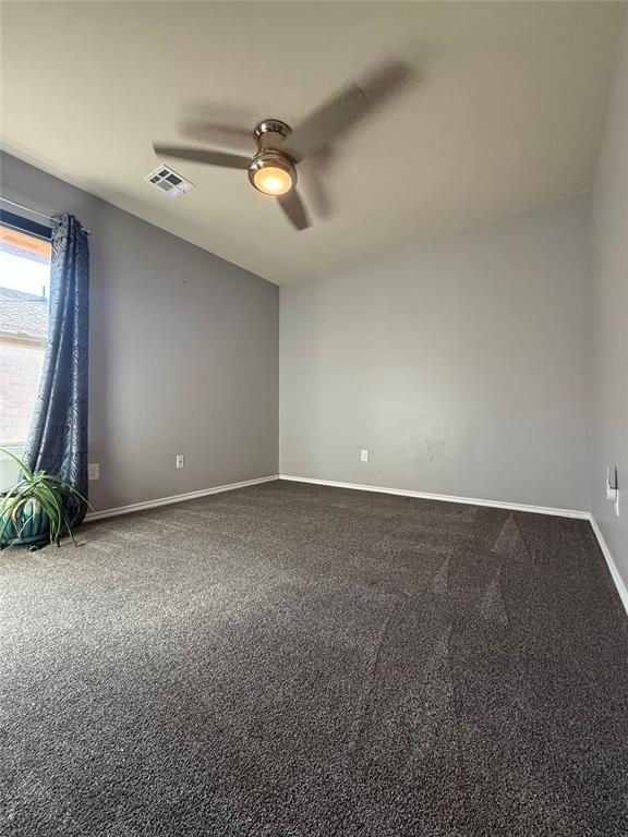 carpeted spare room with ceiling fan