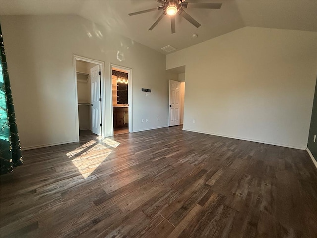 unfurnished bedroom featuring dark hardwood / wood-style flooring, ceiling fan, a spacious closet, a closet, and lofted ceiling