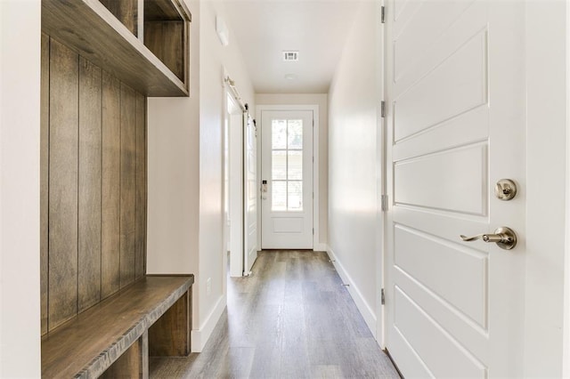 mudroom featuring a barn door and light hardwood / wood-style flooring