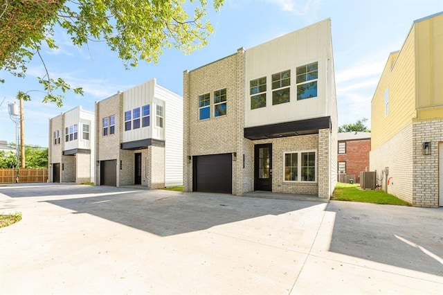 view of front of home featuring central air condition unit and a garage