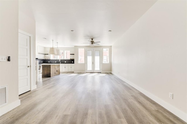 unfurnished living room featuring light hardwood / wood-style floors and ceiling fan