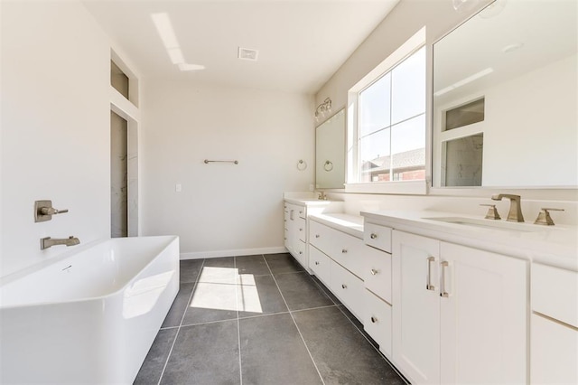 bathroom with tile patterned flooring, vanity, and a bathing tub