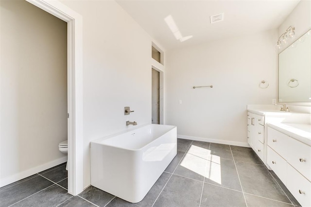 bathroom featuring tile patterned flooring, vanity, toilet, and a bath