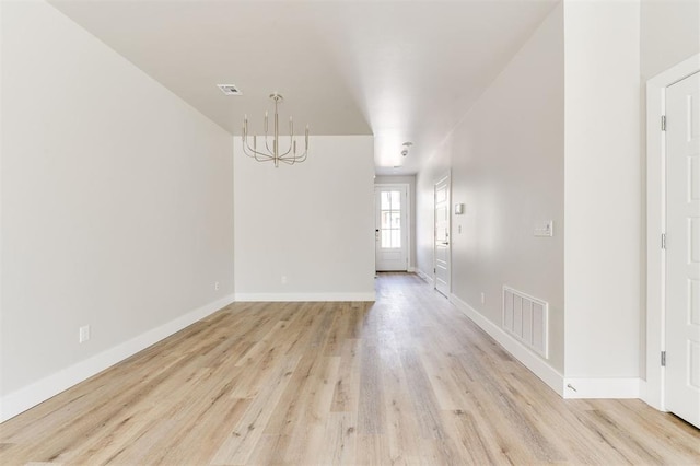 unfurnished dining area featuring light hardwood / wood-style flooring and a notable chandelier