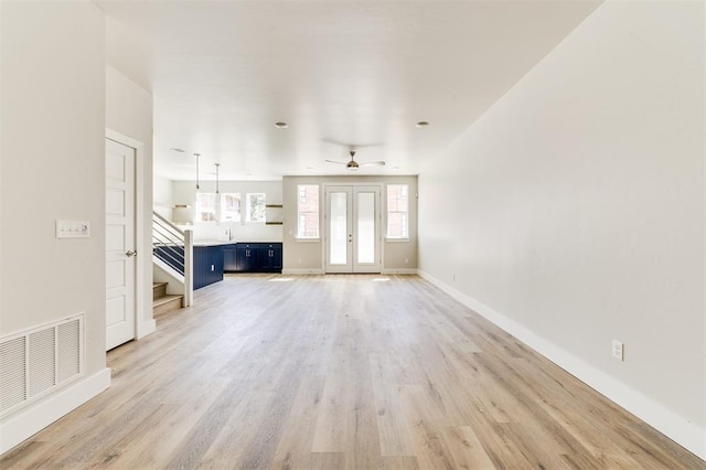 unfurnished living room featuring light wood-type flooring and ceiling fan