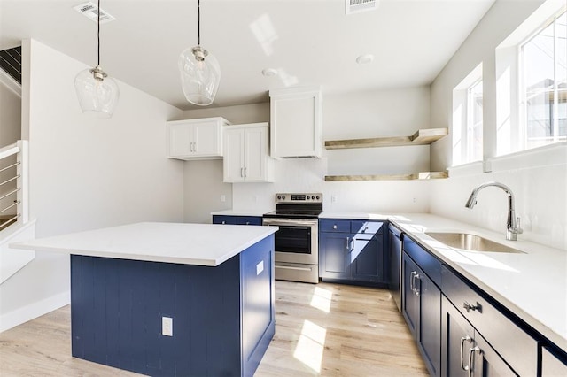 kitchen with appliances with stainless steel finishes, blue cabinets, pendant lighting, light hardwood / wood-style flooring, and white cabinets