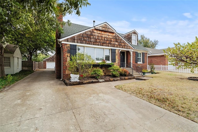 view of front of home featuring a garage, a front lawn, and an outdoor structure