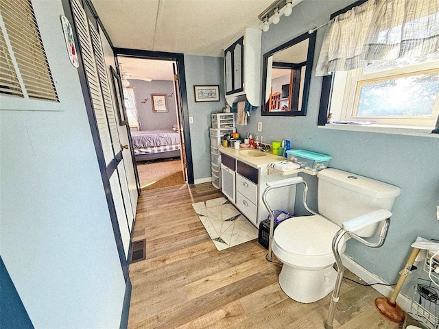 bathroom with hardwood / wood-style flooring, vanity, and toilet